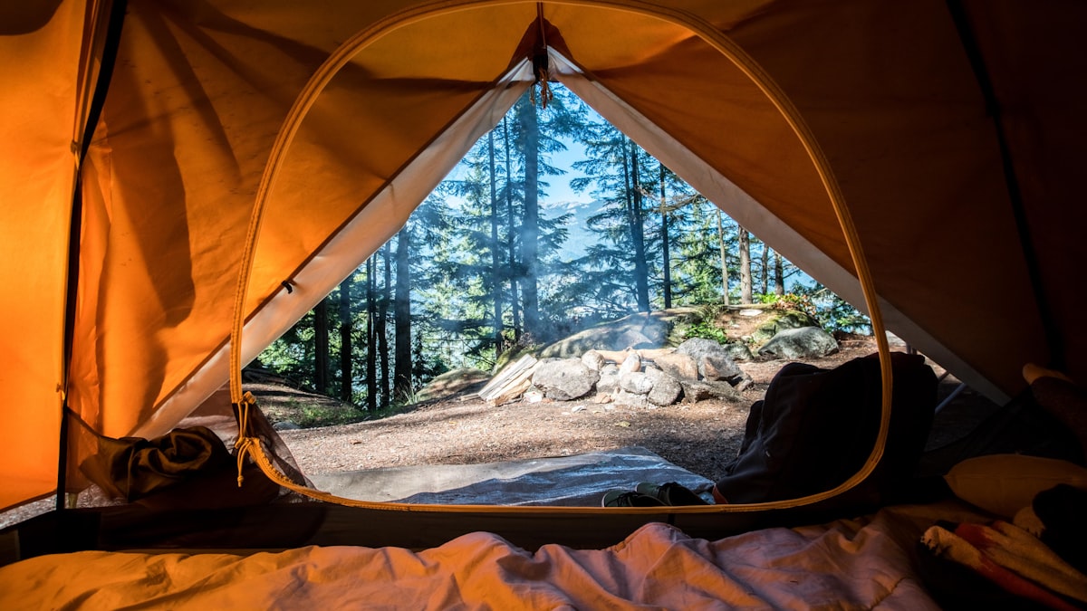 A family tent set up at a mountain campsite at sunset